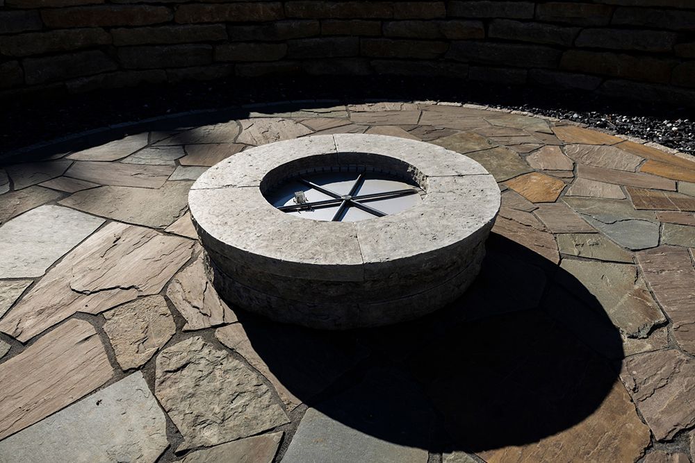 A fire pit is sitting on top of a stone patio.