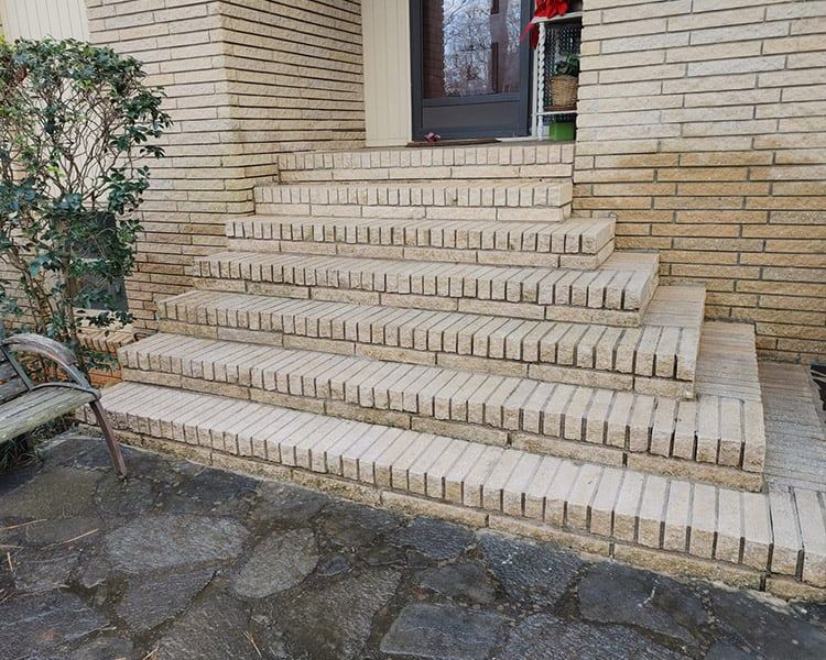 A set of brick stairs leading up to the front door of a house.