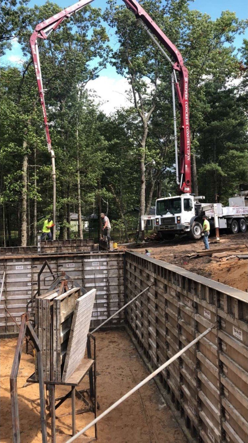 A concrete pump is being used to pour concrete into a wall.