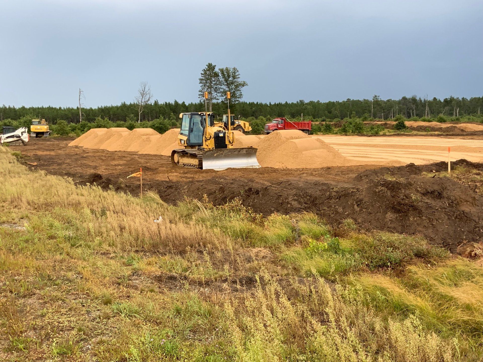 A bulldozer is moving dirt in a field.
