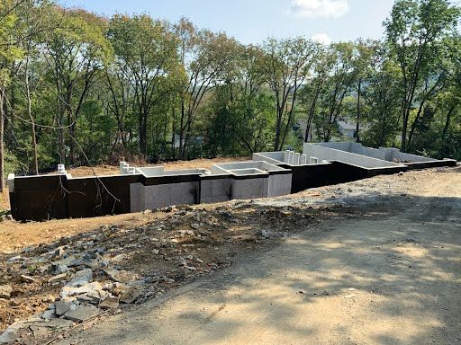 A house is being built on a hill with trees in the background.