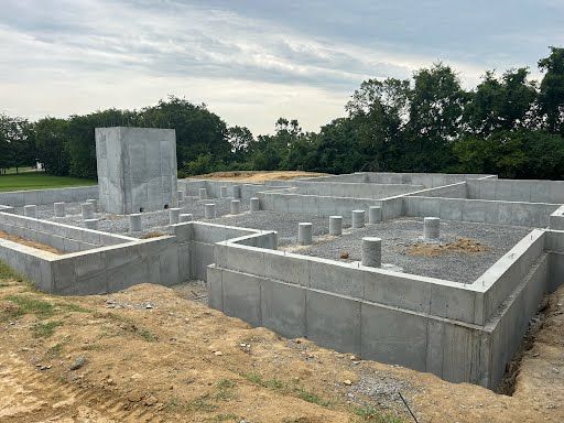 A concrete foundation for a house is being built in a field.