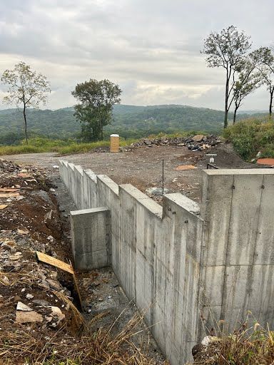 A concrete wall is being built in the middle of a dirt field.