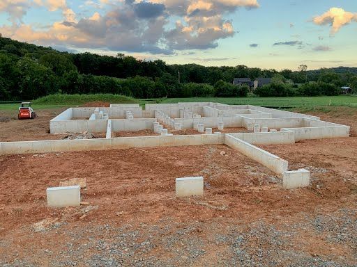 The foundation of a house is being built in a dirt field.