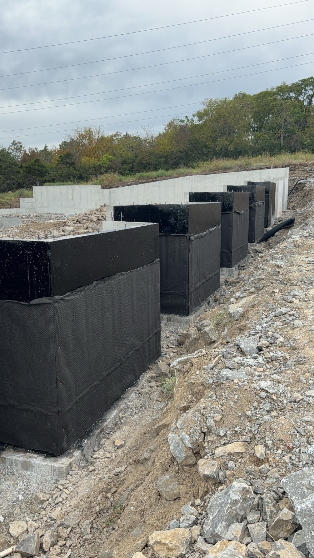 A row of concrete blocks sitting on top of a dirt field.