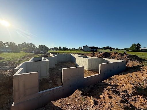 A concrete foundation for a house is being built in a field.