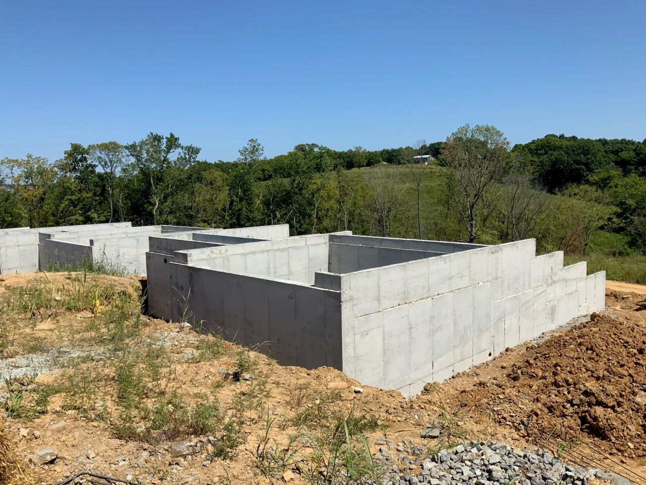 A concrete base for a house is being built in a field.