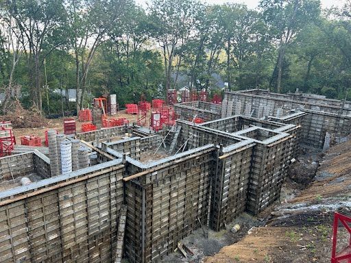 A large concrete wall is being built on a construction site.
