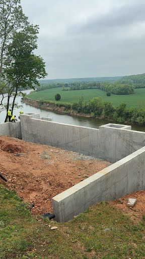 A concrete wall is being built next to a river.