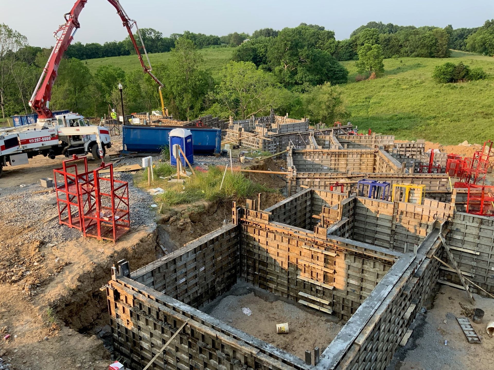 A large concrete foundation is being poured on a construction site.