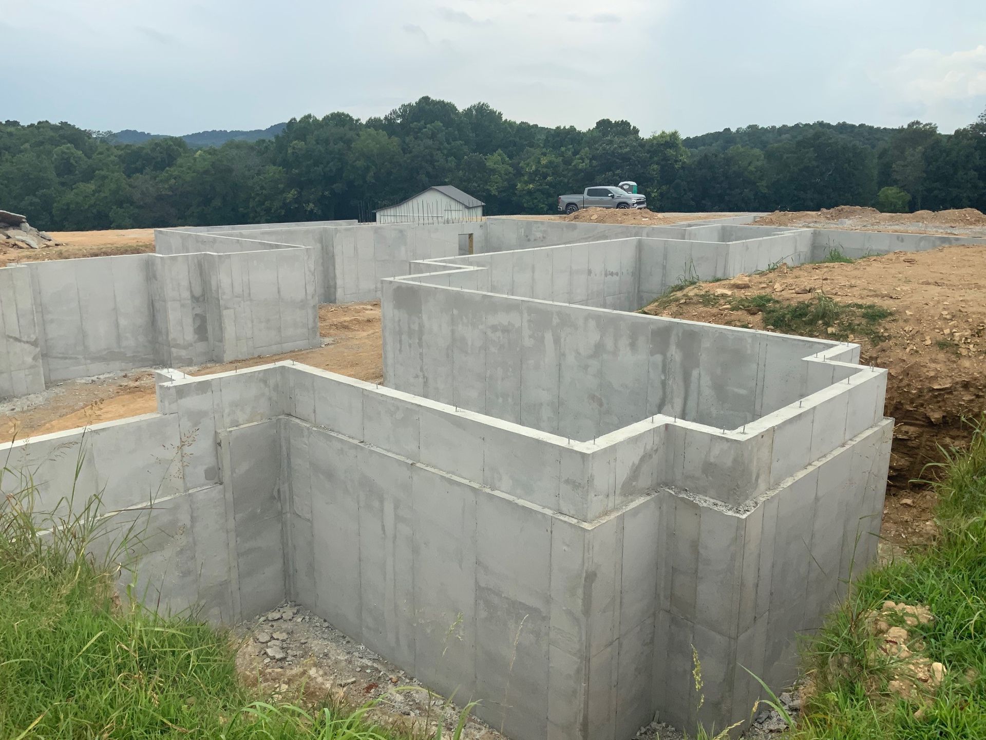 A concrete foundation for a house is being built in a field.