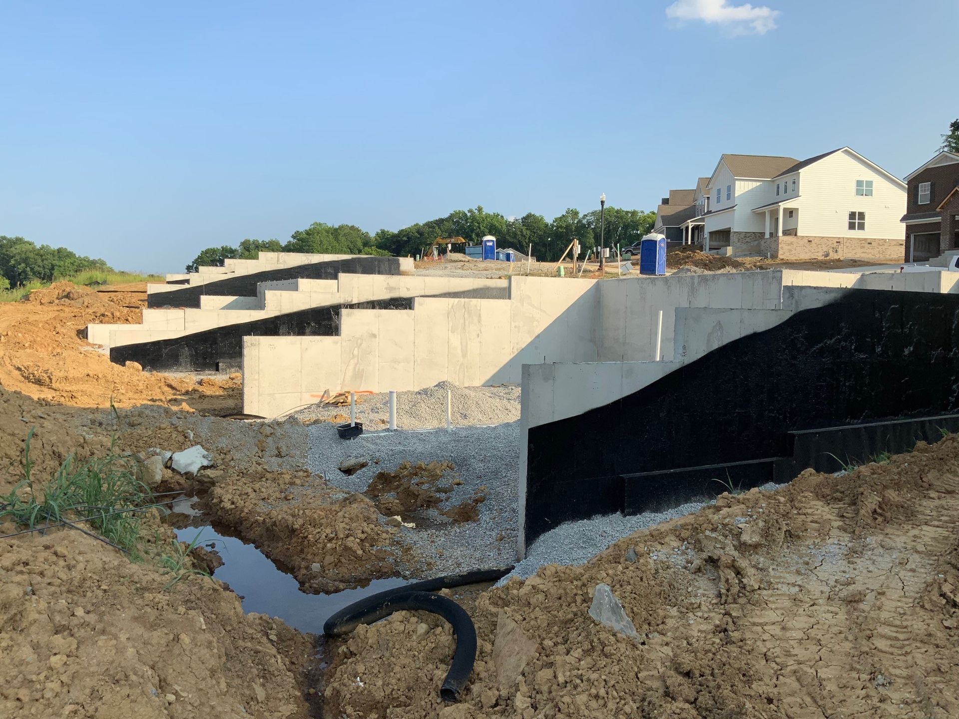 A construction site with a lot of dirt and a house in the background