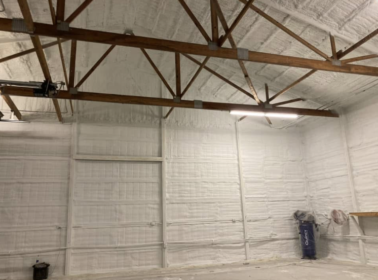 A warehouse with a white ceiling and wooden beams.