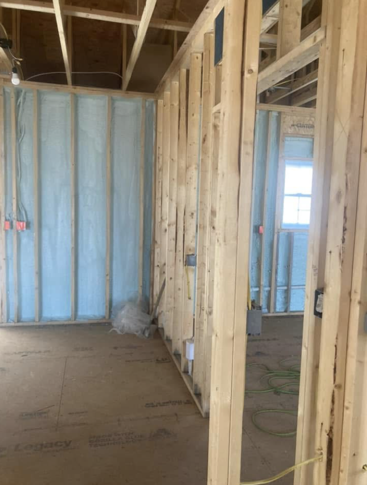 A room with a lot of wooden beams and insulation on the walls.