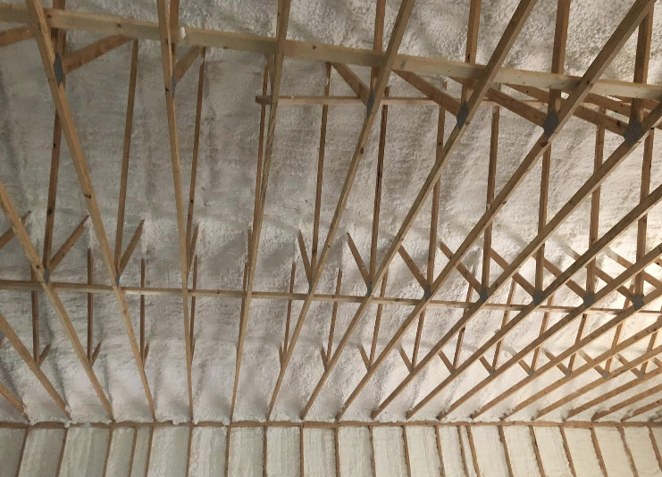 A ceiling with a lot of wooden beams and foam on it.