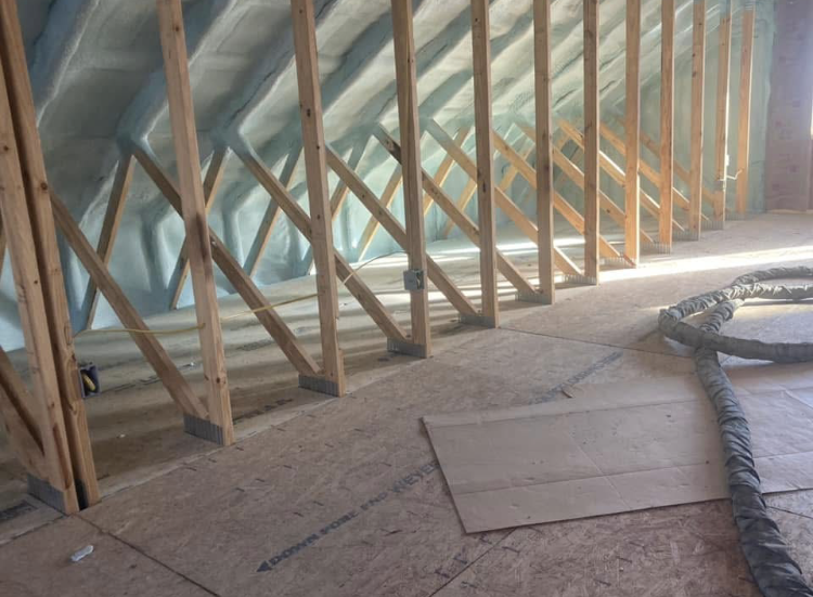 A room with a lot of wooden beams and a hose on the floor.