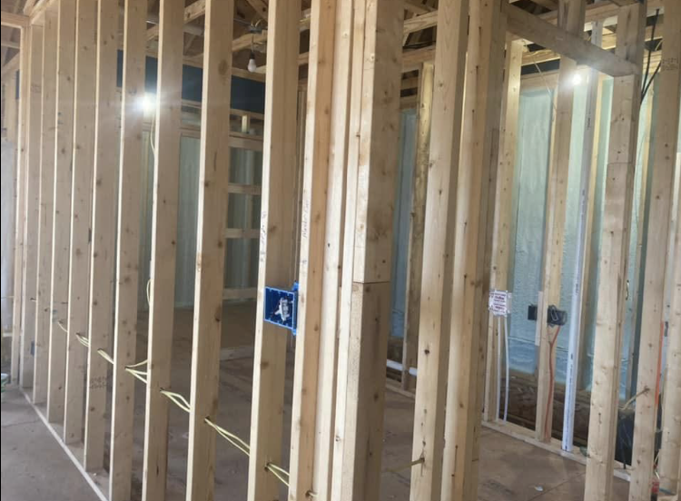 A hallway in a house under construction with wooden beams.