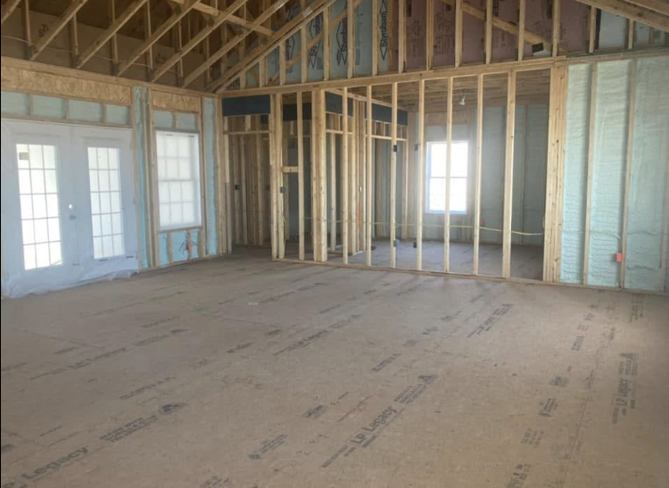 A large empty room in a house under construction.