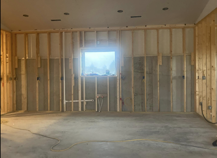 An empty room with wooden walls and a window.