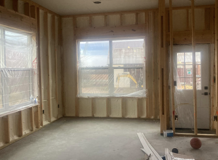 A living room in a house under construction with a basketball on the floor.