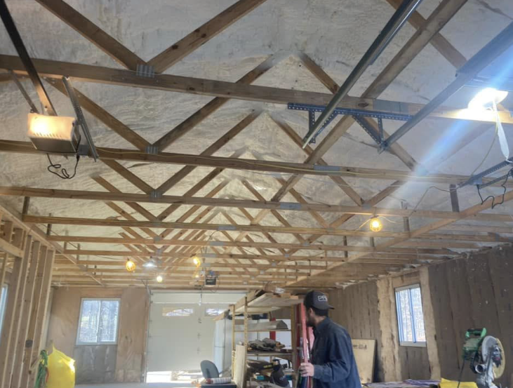 A man is working on the ceiling of a garage.