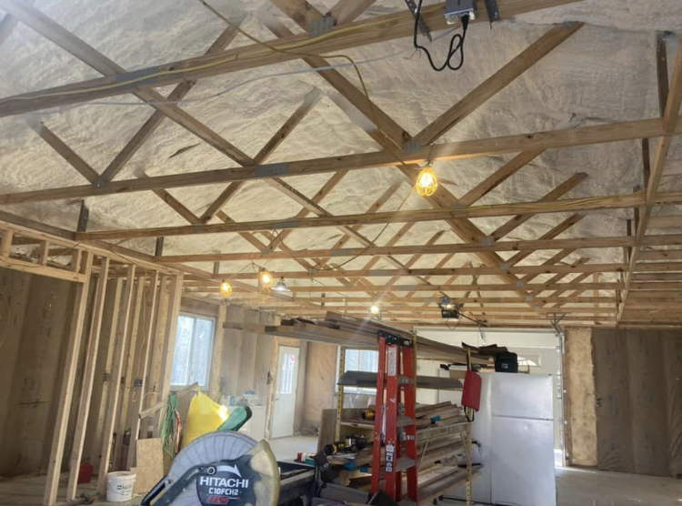 A room under construction with a ladder and a refrigerator.