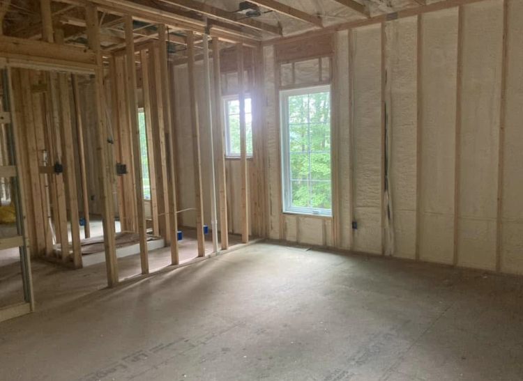 An empty room in a house under construction with a window.