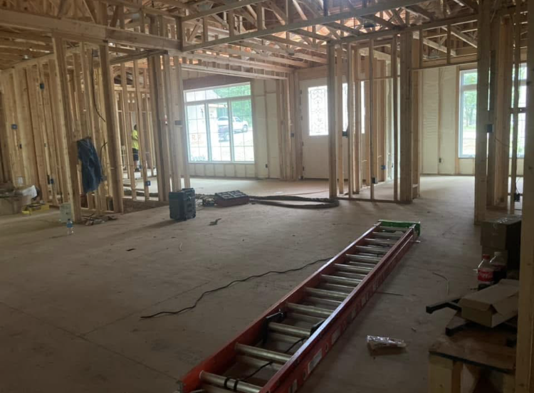 A ladder is sitting on the floor of a building under construction.