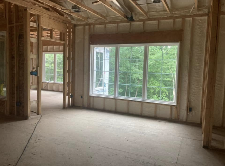 A room with a lot of windows in a house under construction.