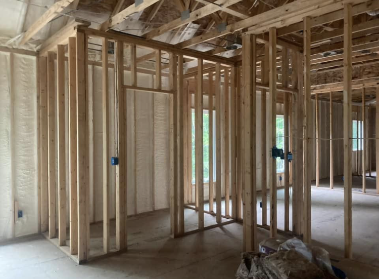 The inside of a house under construction with a lot of wooden beams.