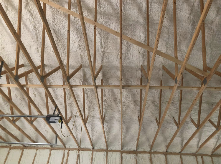 A ceiling with a lot of wooden beams and foam on it.