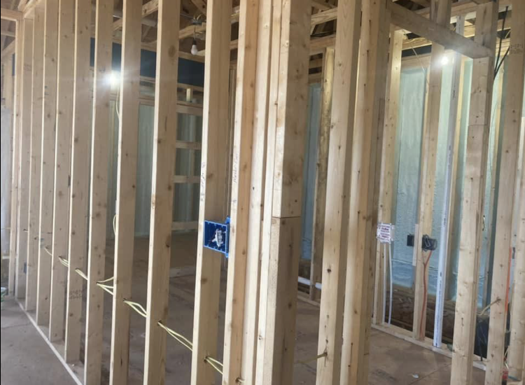 A hallway in a house under construction with wooden beams.