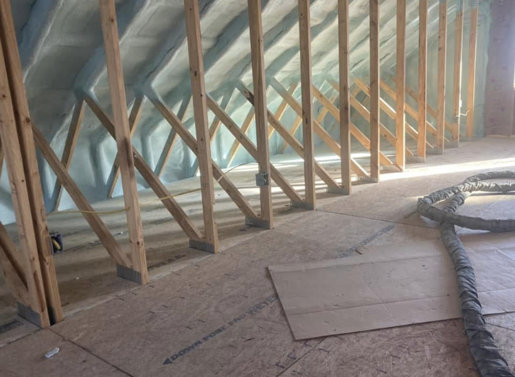 A room with a lot of wooden beams and a hose on the floor.