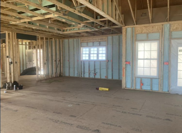 A room in a house under construction with a lot of windows