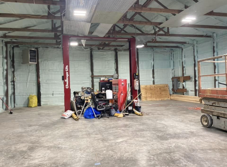 A garage with two lifts and a scissor lift in it.