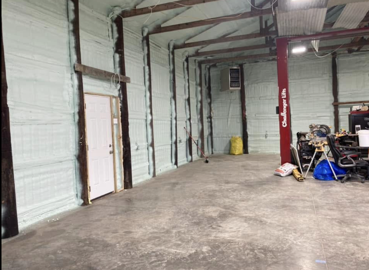 A large empty room with a door and a heater on the wall.