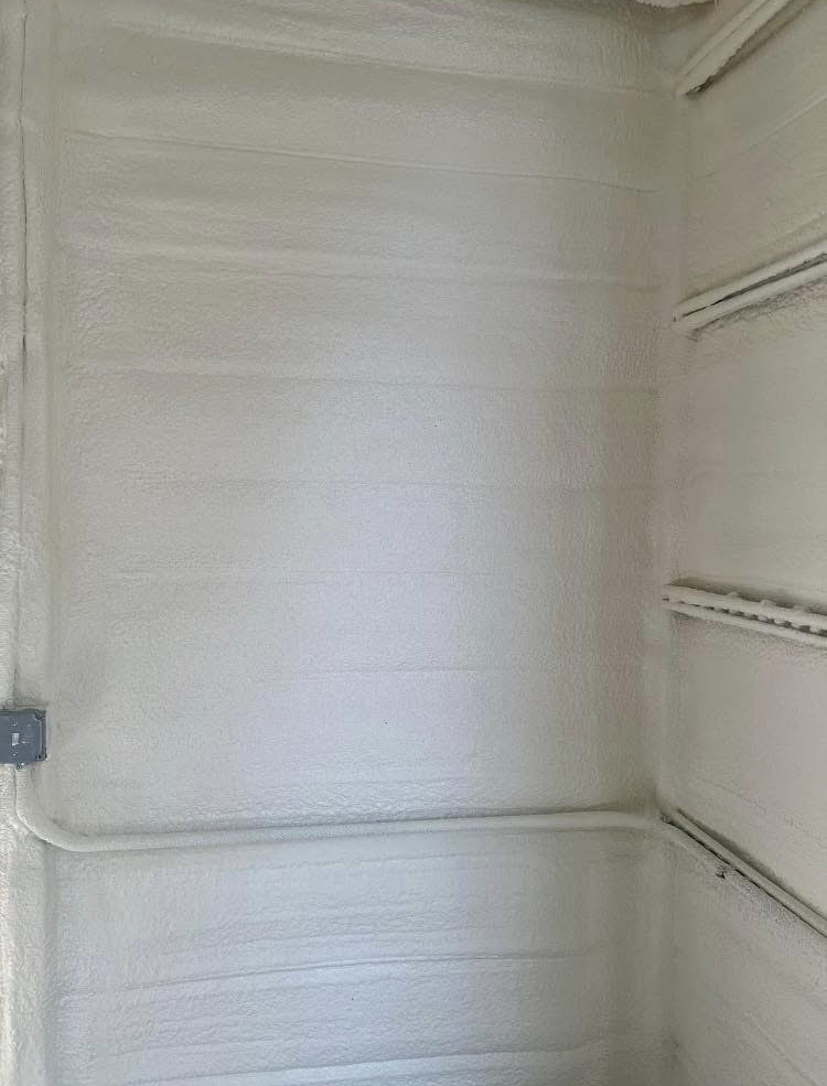 A room with a white wall and shelves in it.