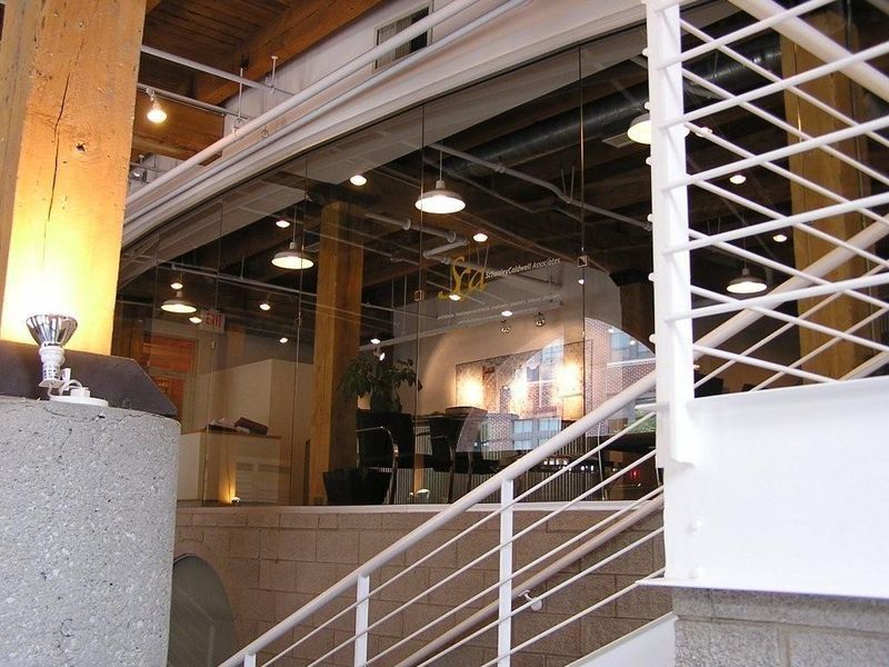 Interior with a staircase, exposed beams, and hanging lights in a modern open room