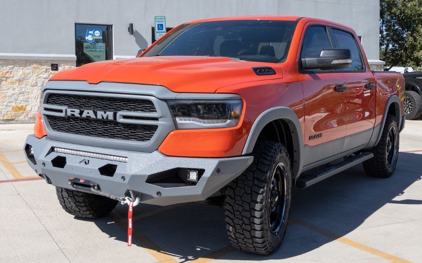 A red ram truck is parked in a parking lot.