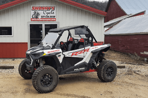 A black and white UTV is parked in front of a building.