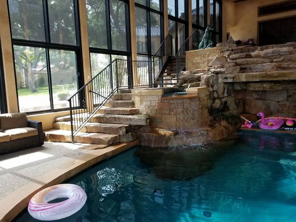 A large indoor swimming pool with stairs leading up to it.