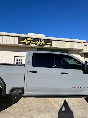 A white truck is parked in front of a building.
