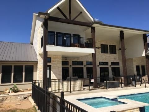 A large house with a swimming pool in front of it