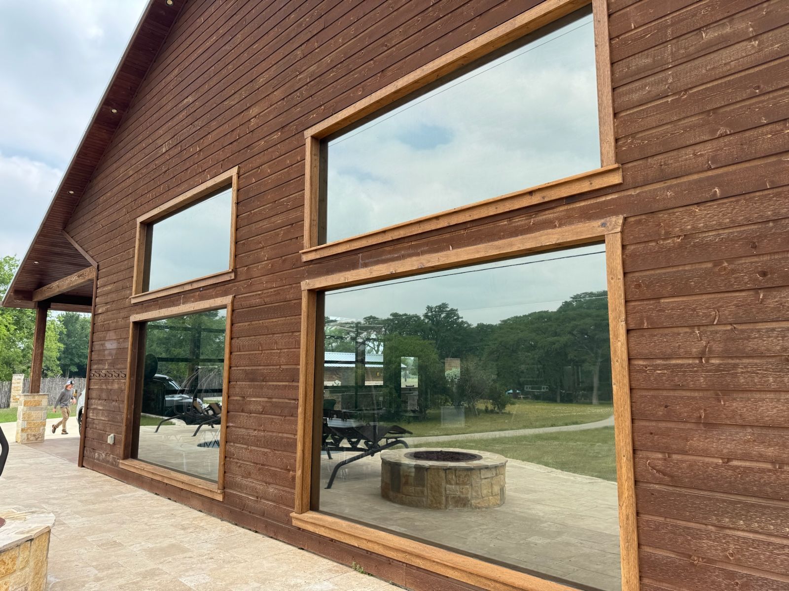 A large wooden building with a lot of windows and a fire pit in front of it.