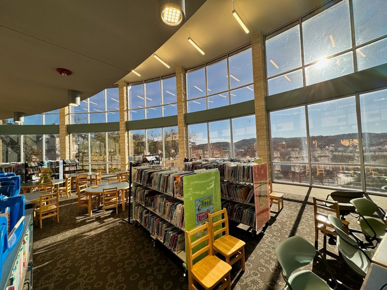 A library with a lot of windows and chairs