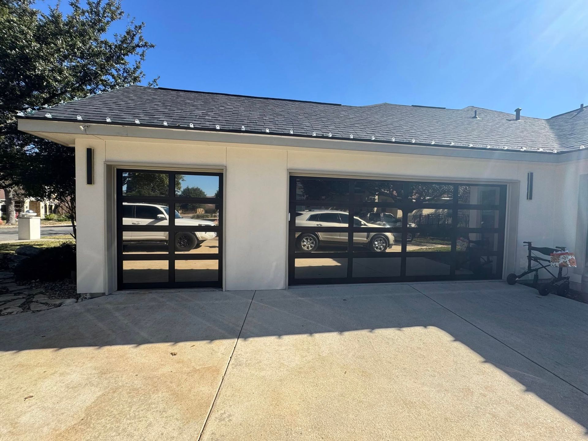 A white house with a large garage door and a car parked in front of it.