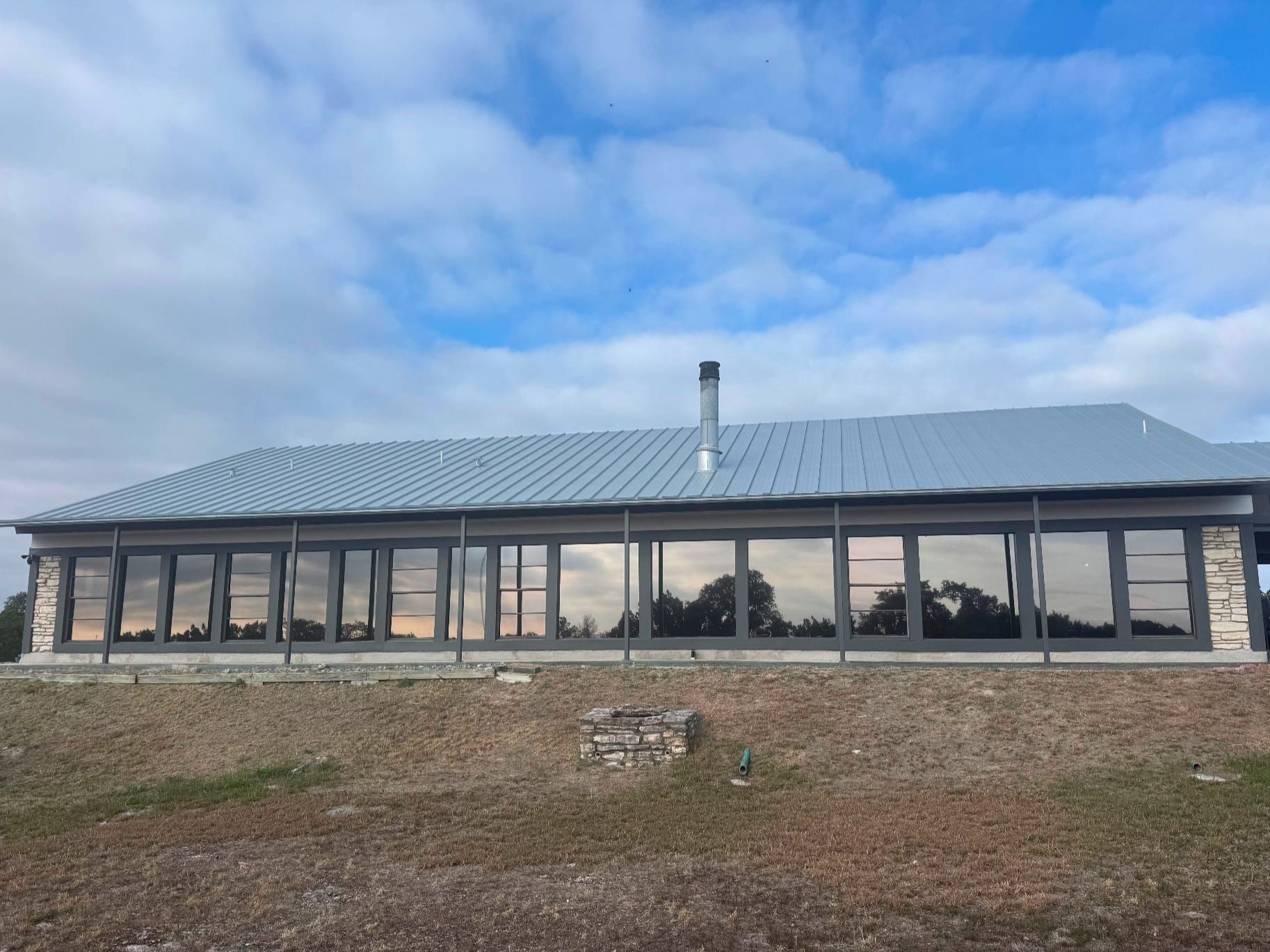 A large house with a lot of windows and a chimney on the roof.