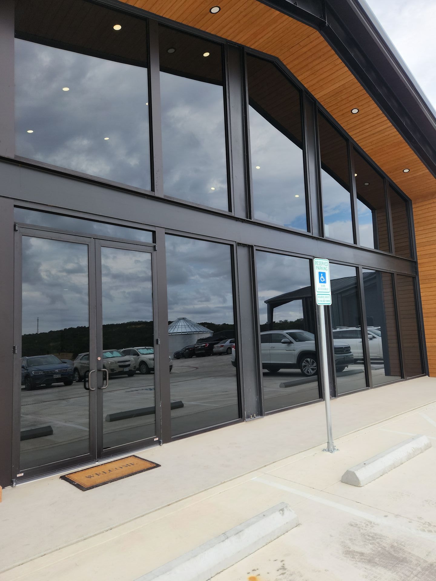 A building with a lot of windows and a parking sign in front of it.