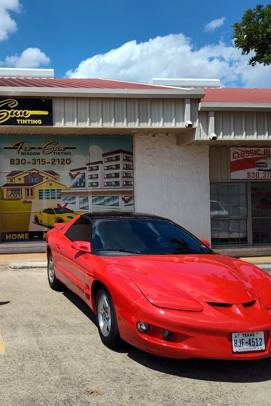A red sports car is parked in front of a building.