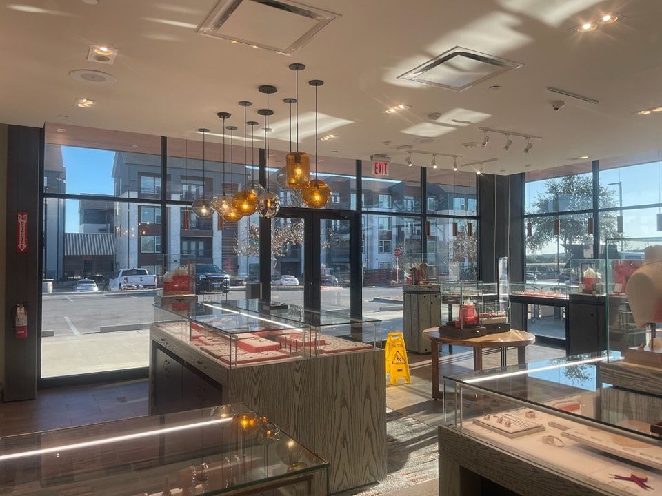 A jewelry store with a lot of windows and a yellow caution sign on the floor.